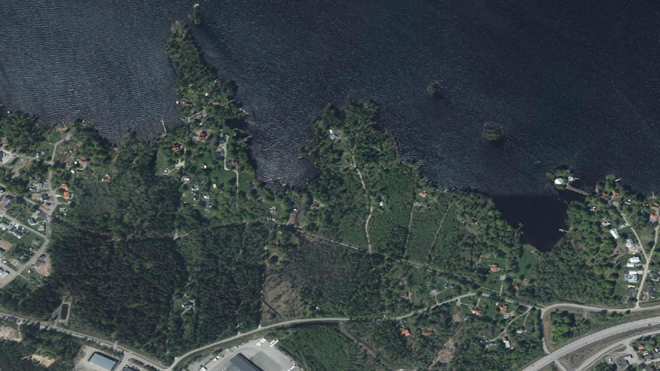 Flygfoto över området Hagavik. Skog, bostadsområden, grönytor, infrastruktur och vatten. 